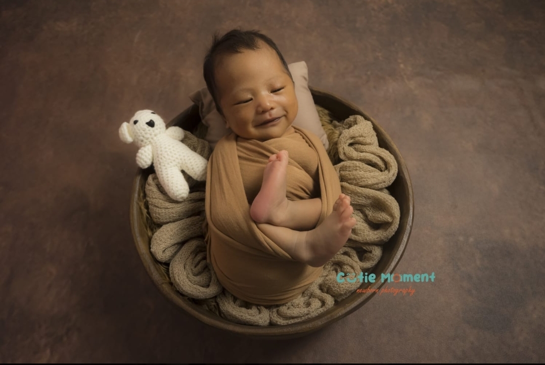 Foto bayi tersenyum di dalam properti mangkuk